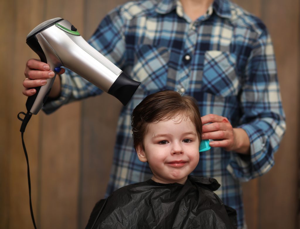 little boy is trimmed hairdresser s bright emotions his face scaled